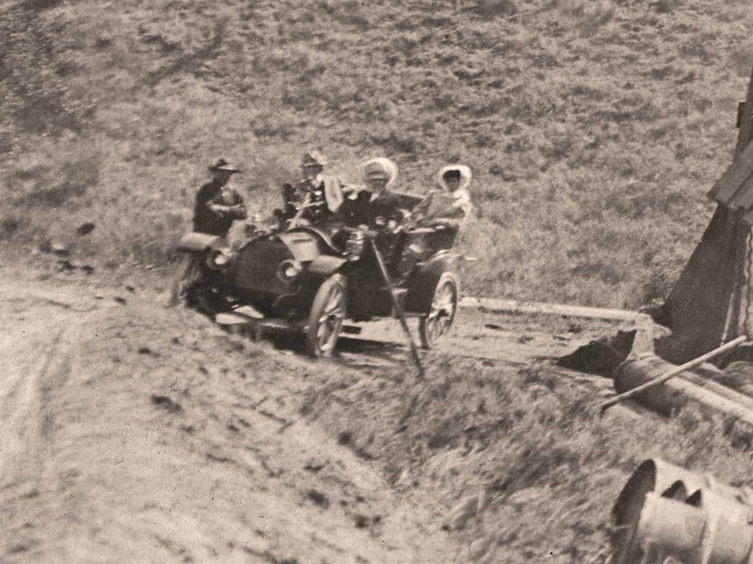 Detail from a 1915 photograph of an oil rig in Waterton, showing a car with three passengers and another standing beside it